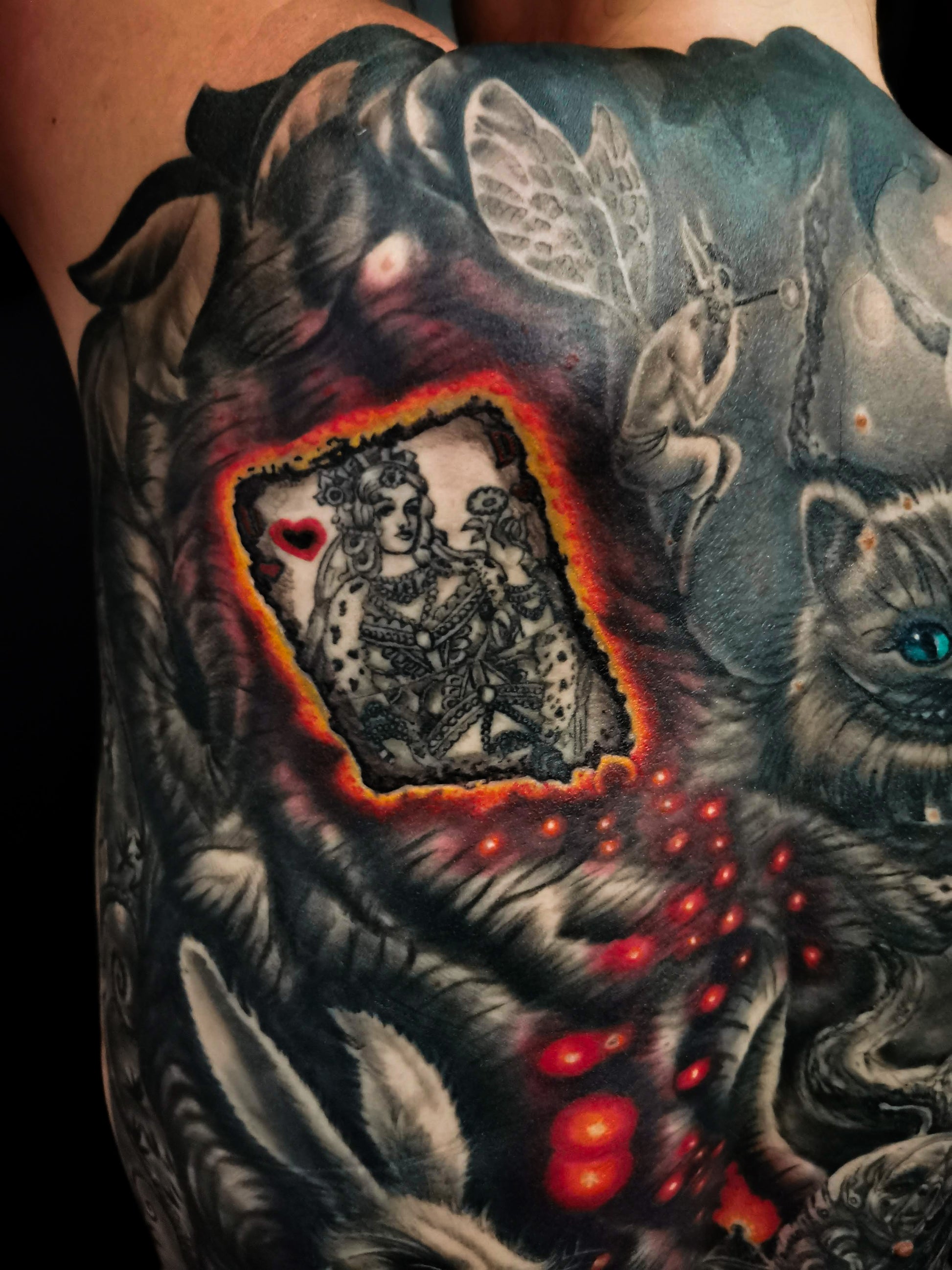 Detailed full back tattoo design of Alice in Wonderland with a rabbit, glowing eyes, and mystical elements