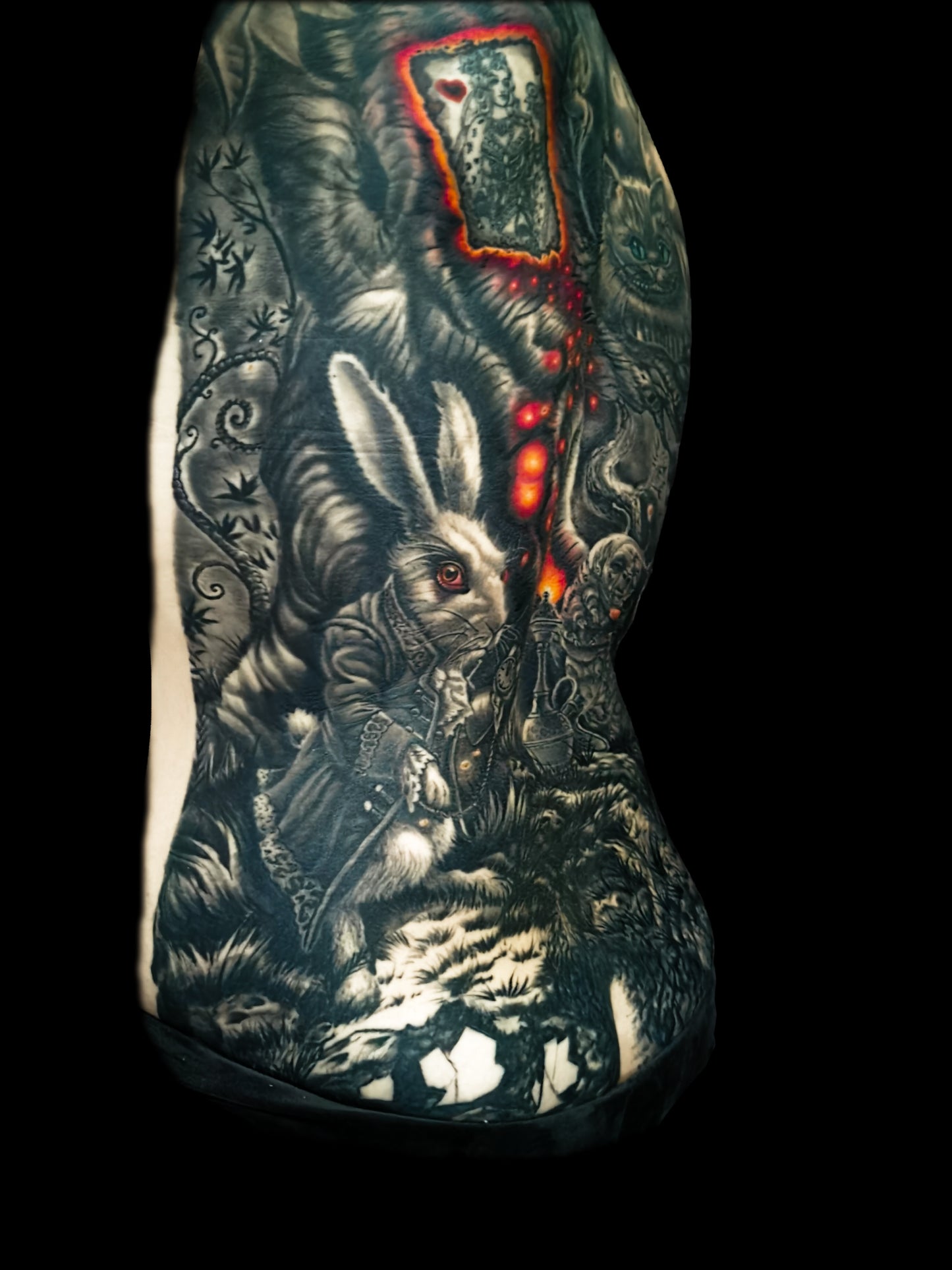 Detailed full back tattoo design of Alice in Wonderland with a rabbit, glowing eyes, and mystical elements