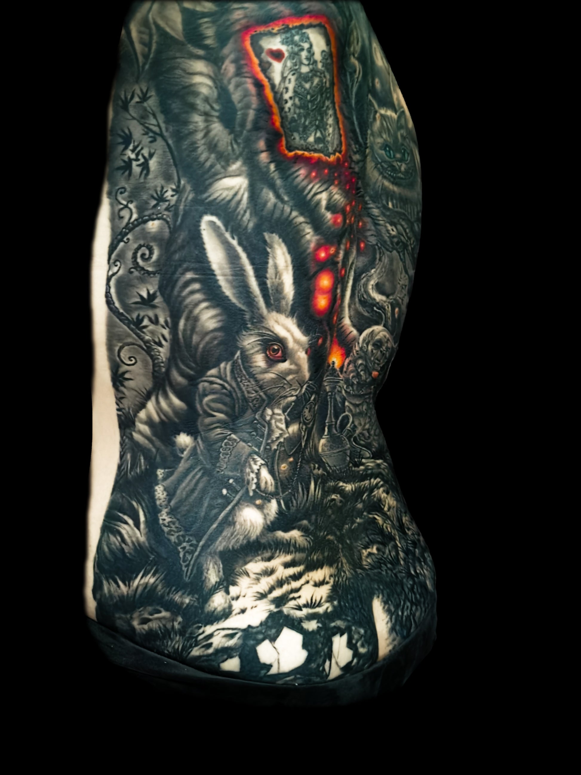 Detailed full back tattoo design of Alice in Wonderland with a rabbit, glowing eyes, and mystical elements