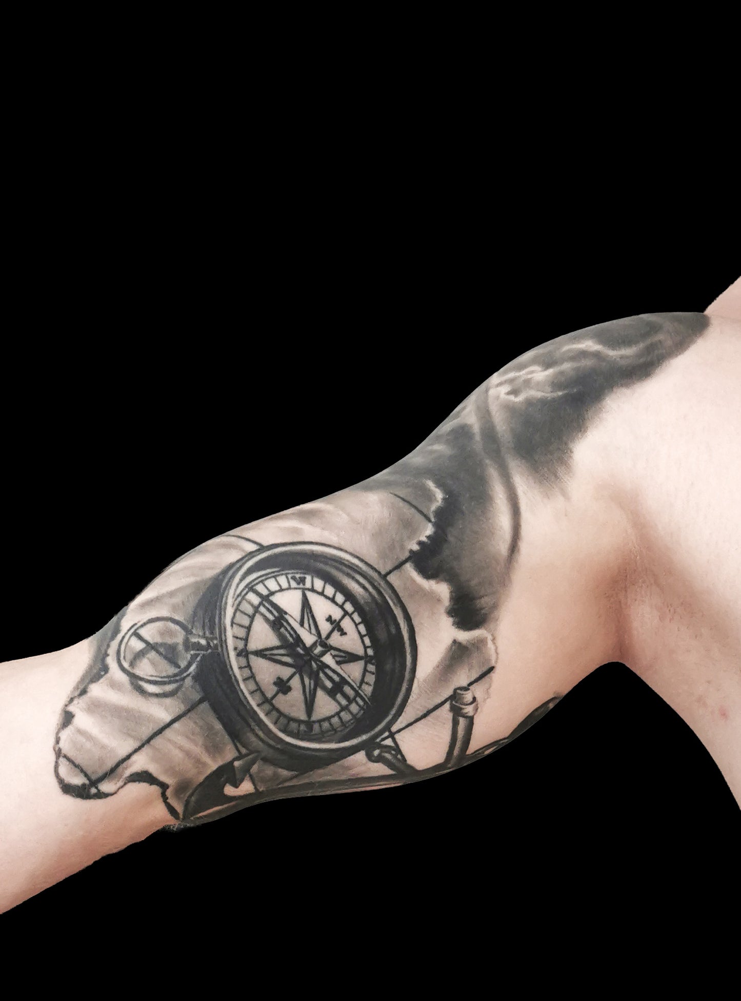 Halfsleeve tattoo on a person's right arm with anchor, compass, map and a ship in storm amongst waves and sunrays from the dark clouds