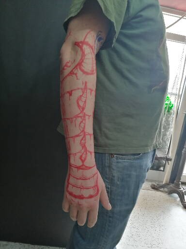 Detailed freehand cover up for metallic arm armor on a black background