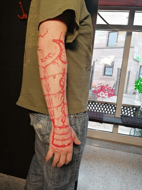 Detailed freehand cover up for metallic arm armor on a black background