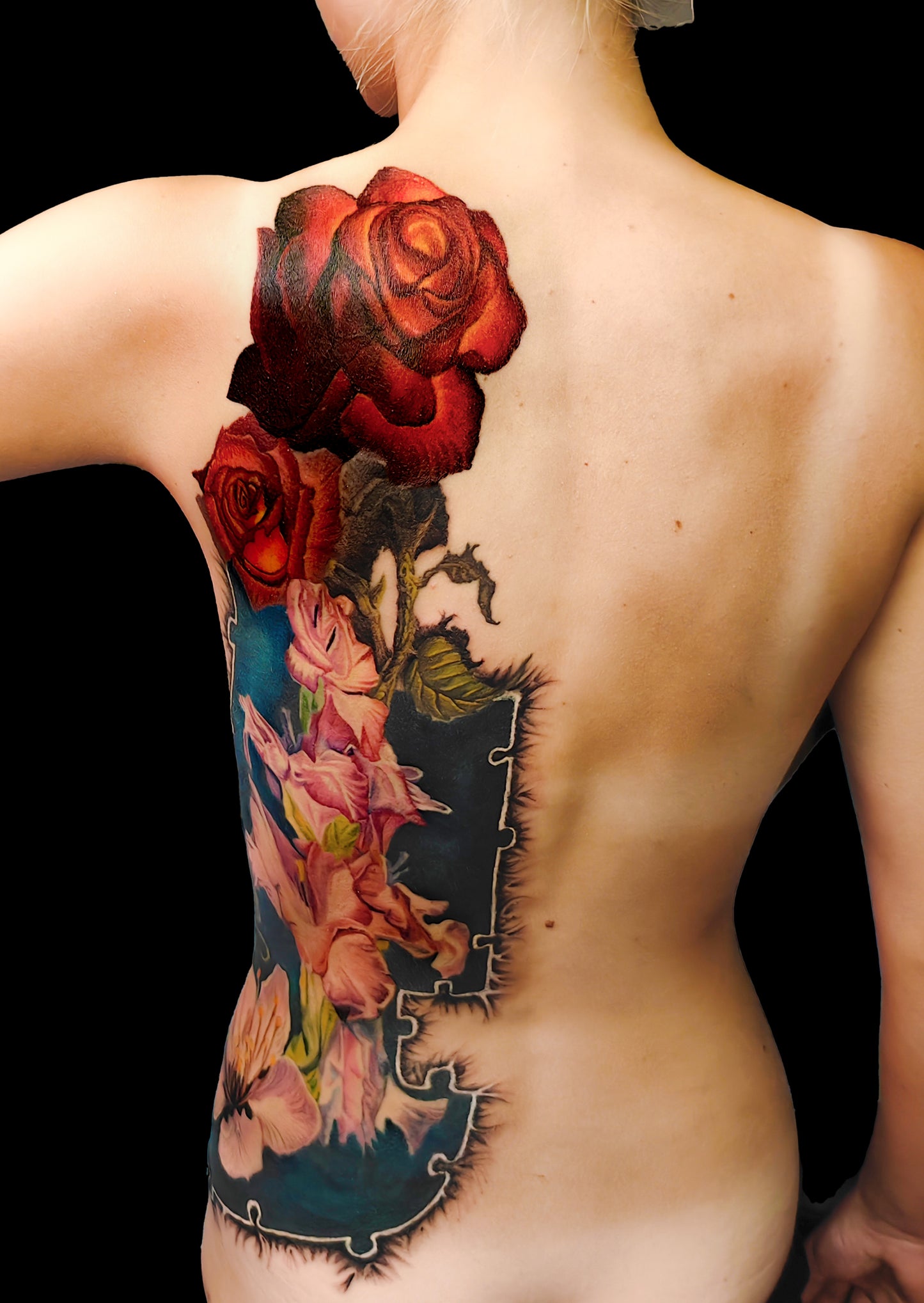 Colorful floral cover-up tattoo on the half torso with a puzzle-frame edge and a pocket watch motif