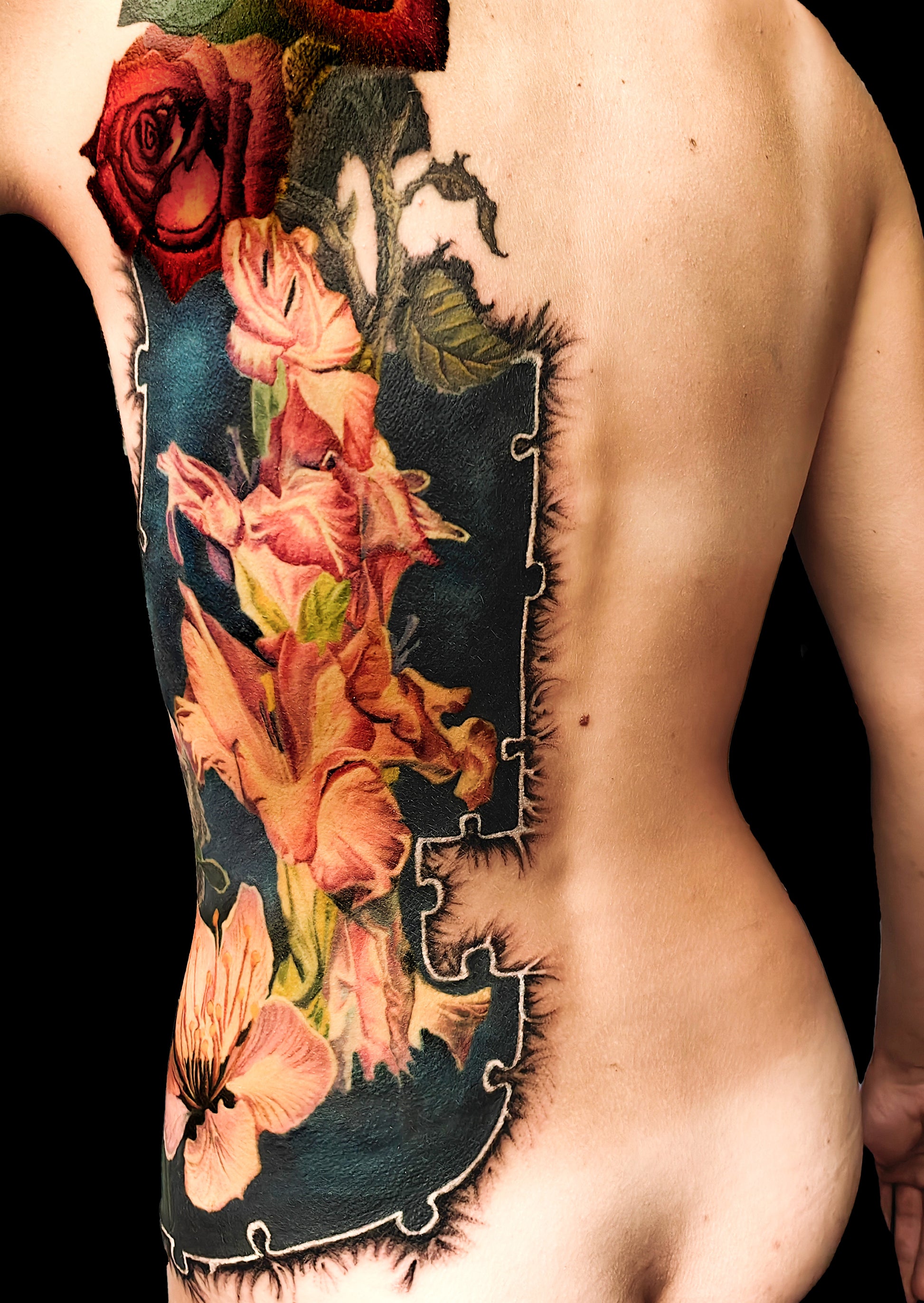 Colorful floral cover-up tattoo on the half torso with a puzzle-frame edge and a pocket watch motif